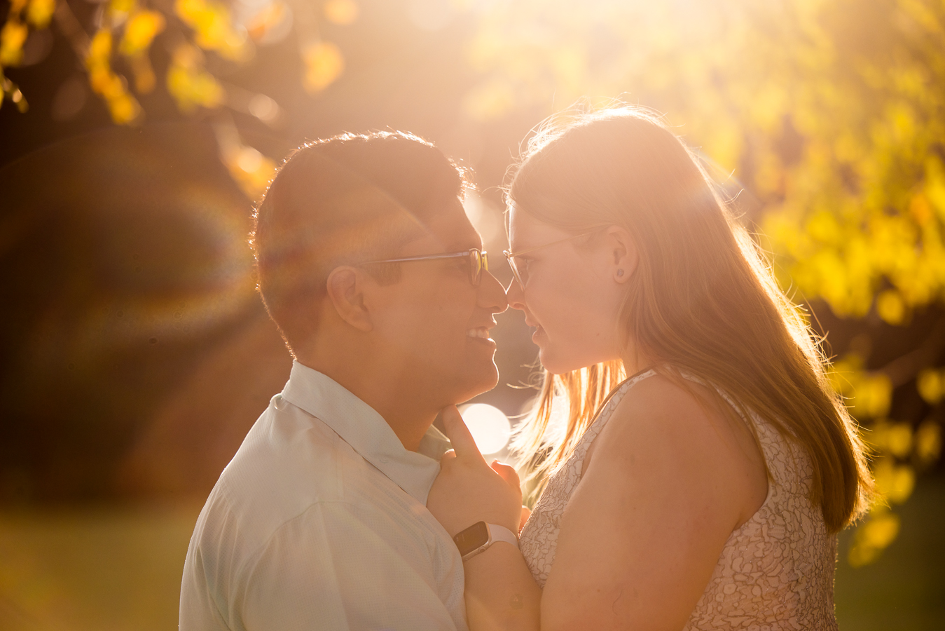 DMV wedding photographer, rhinehart photography, captures this sun lit image of the couple as they stand facing each other and smiling as their noses touch during their intimate wedding ceremony in spencerville maryland