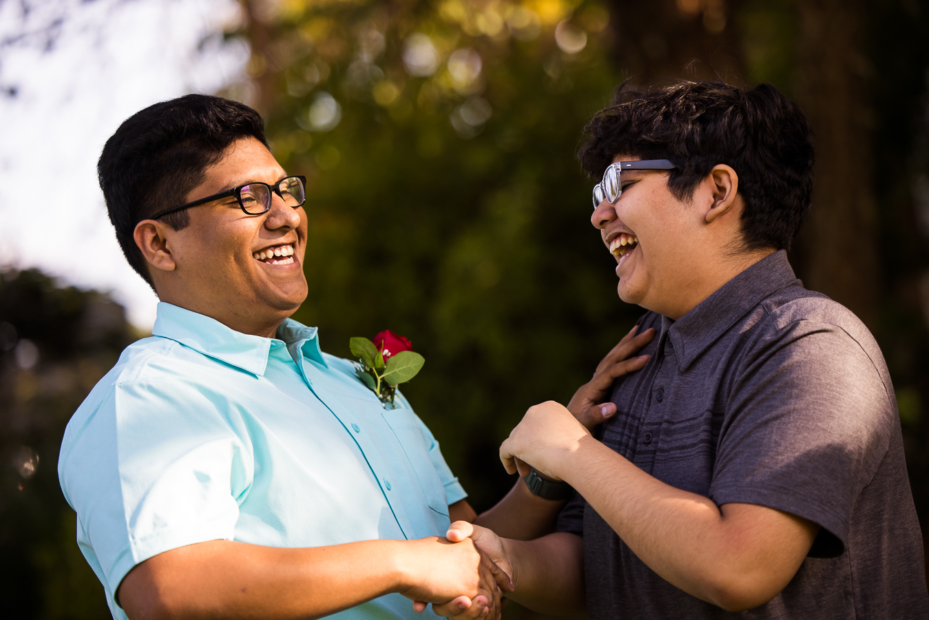 candid maryland wedding photographer, lisa rhinehart, captures this image of the groom with his younger brother as they shake hands and laugh during this intimate wedding ceremony 
