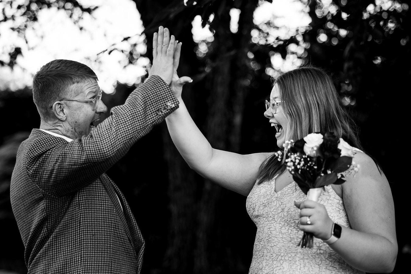 DMV wedding photographer, rhinehart photography, captures this fun, candid image of the bride and her dad high fiving during her intimate wedding ceremony at the cedar ridge community church in spencerville Maryland 