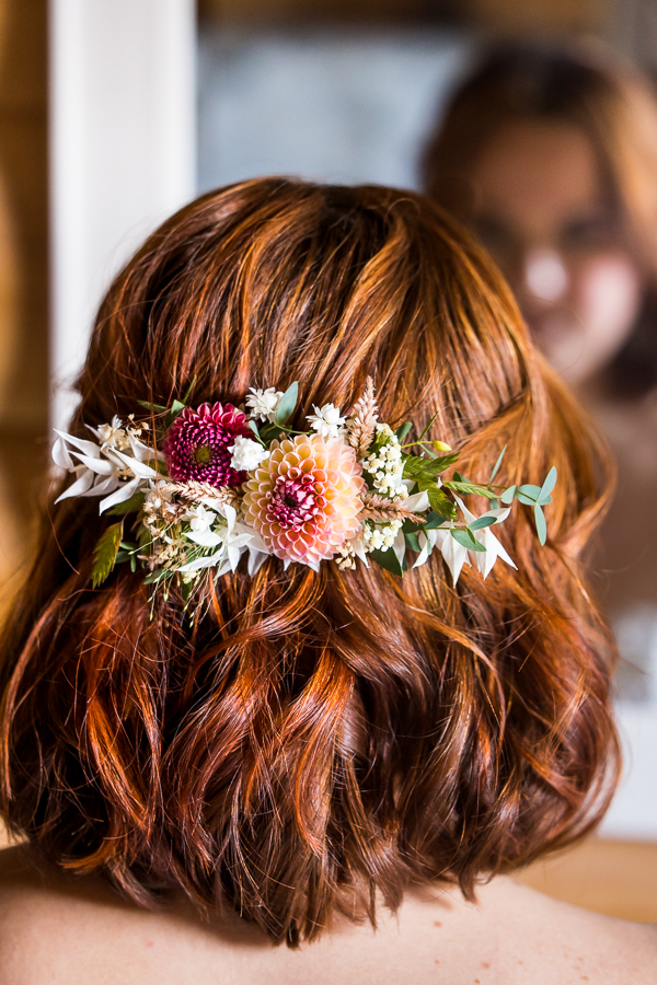 image of the floral accessory created by iron willow floral designs for this wedding venue branding photography shoot features vibrant, colorful florals against red hair 
