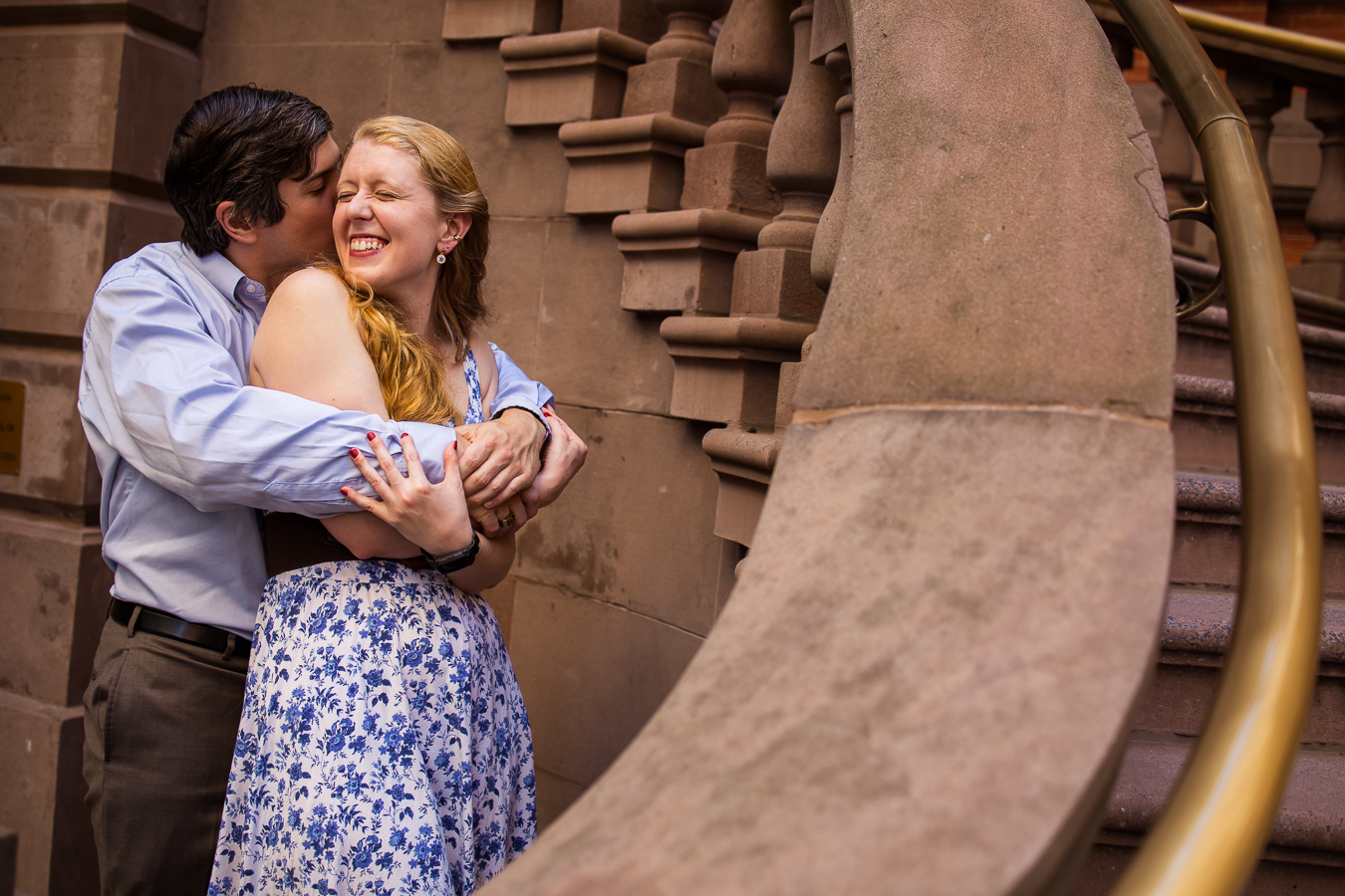 creative unique image of the couple as they stand hugging one another and smiling with the staircase leading your eye right to couple during their philly creative engagement session 