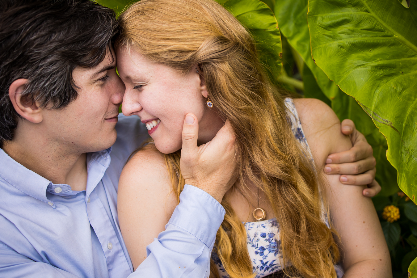 close up image of the couple as they sit beside one another during their engagement session in Philly and touch their heads together while smiling at one another for this vibrant image 