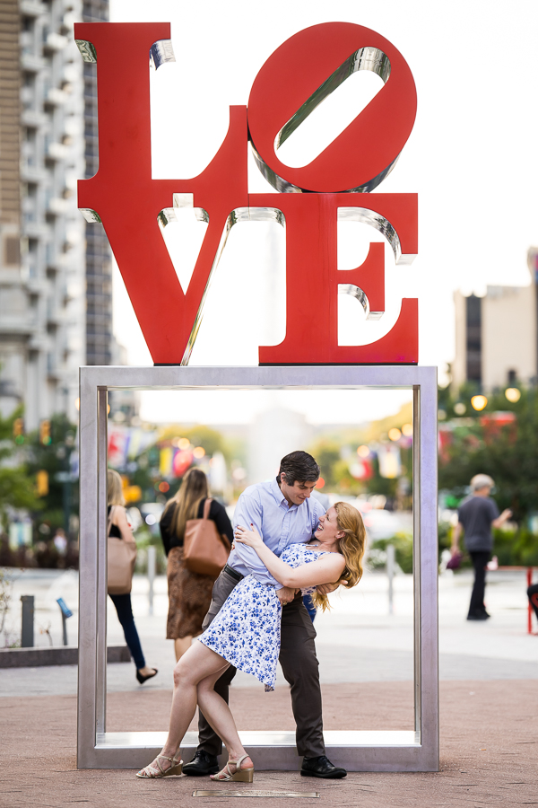 fun, creative, unique image of the couple as they dance with each other in center city philly underneath the famous love sign during their engagement session 