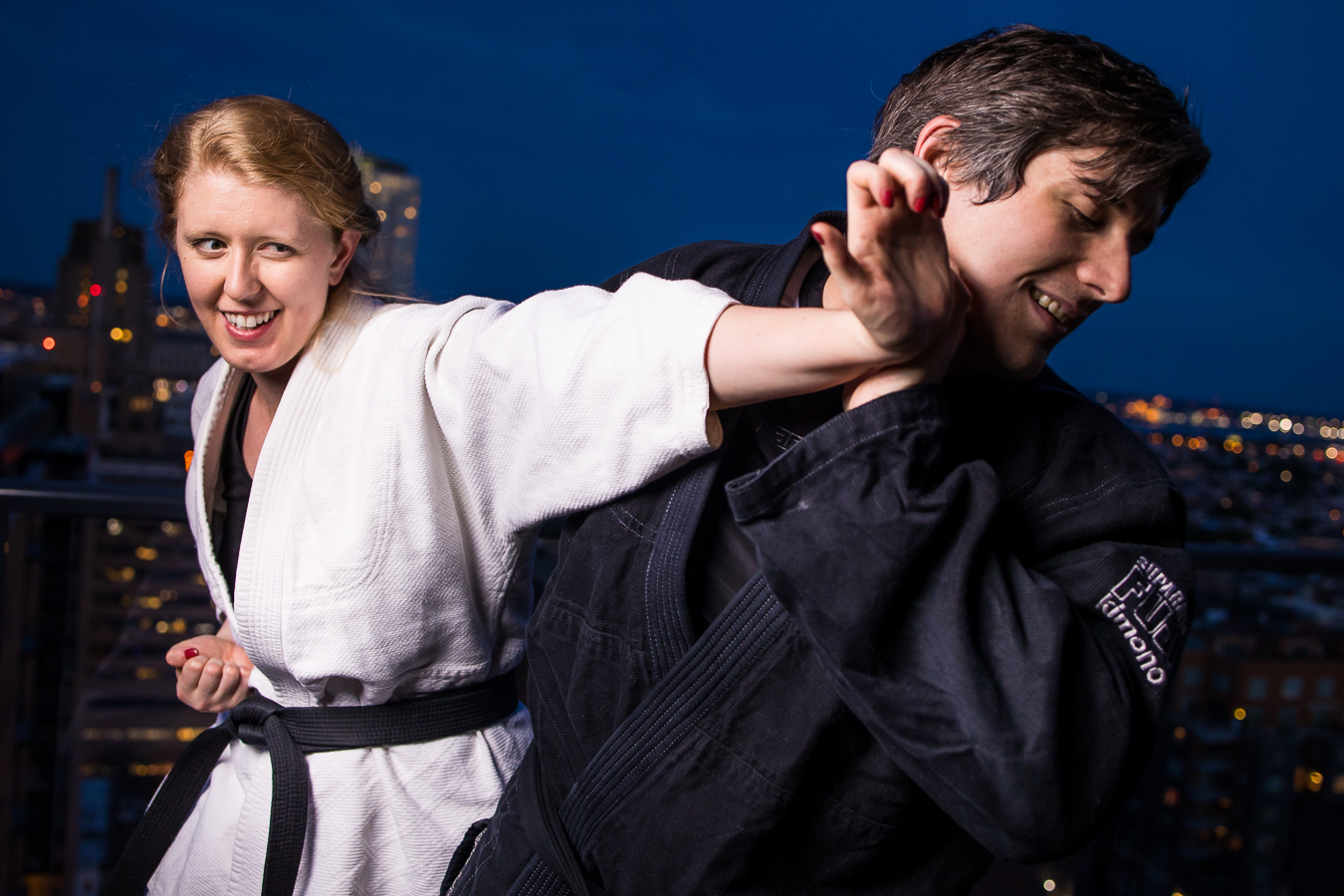 authentic engagement photographer, rhinehart photography, captures this image of the couple as they do jiu-jitsu together on the rooftop of their apartment in center city Philadelphia 