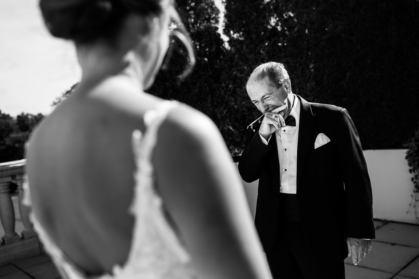 creative nj wedding photographer, rhinehart photography, captures this intimate and sentimental father daughter first look outside of the palace at somerset park in NJ as dad bites his finger after seeing his daughter for the first time in her wedding gown for her black and gold wedding 