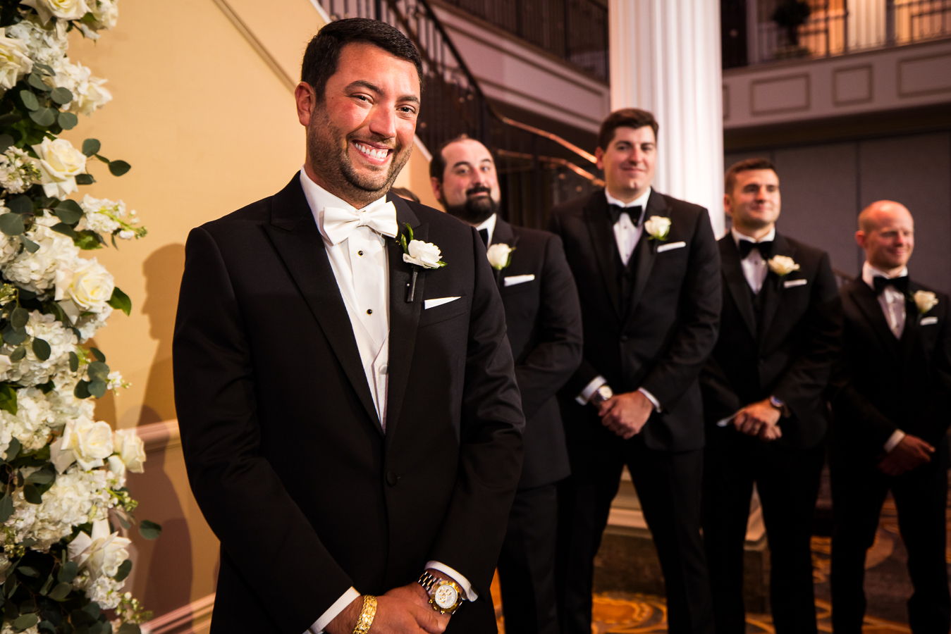 palace wedding photographer, lisa rhinehart, captures this authentic moment of the groom as he smiles so big as he sees his bride walking down the aisle towards him during this nj wedding ceremony 
