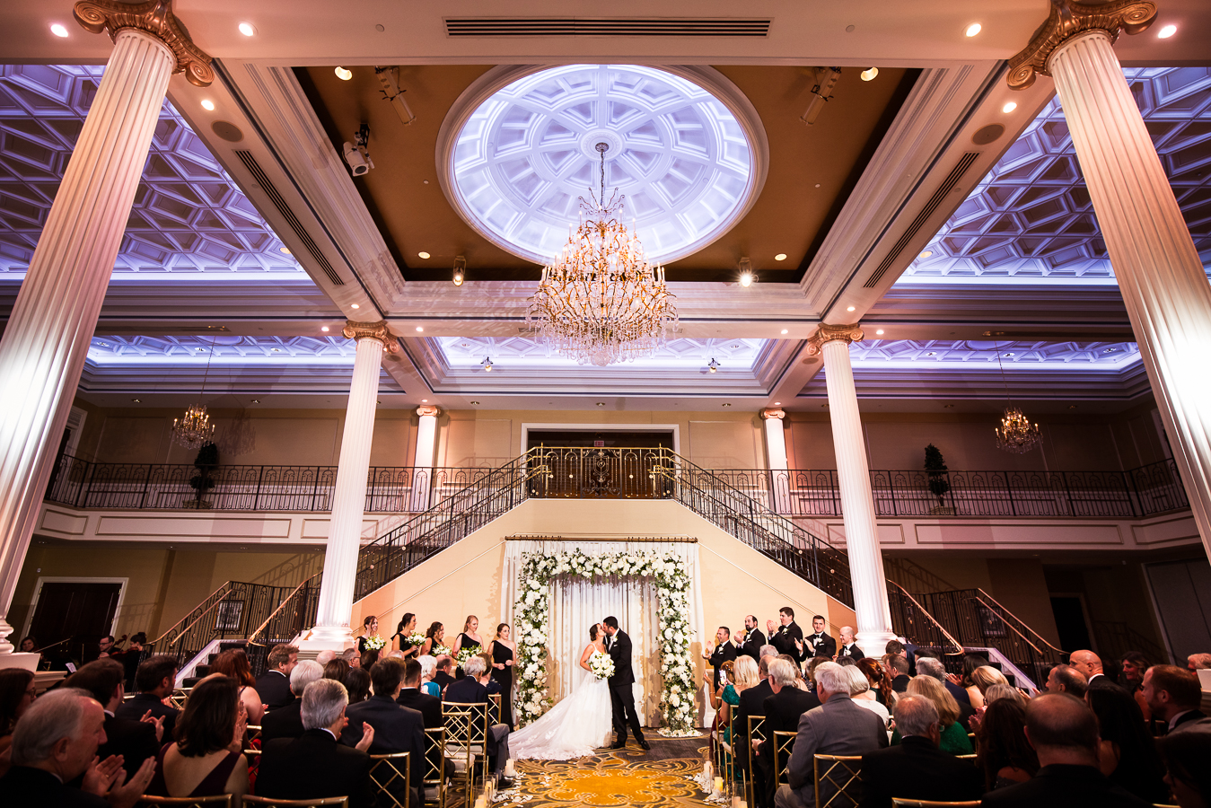 unique, creative perspective of the bride and groom as they share their first kiss with their ceremony space and the guests included in this image captured by palace at somerset park wedding photographer, lisa rhinehart