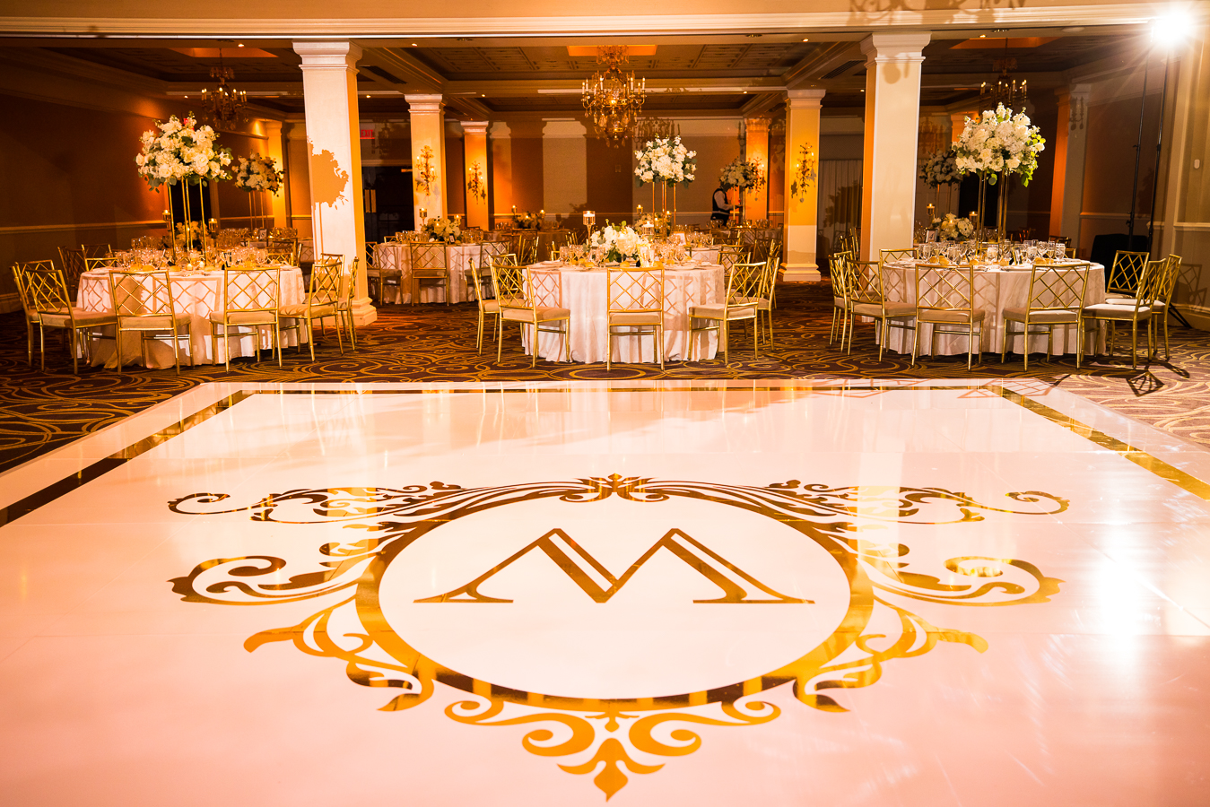the palace at somerset park wedding photographer, lisa rhinehart, captures this black and gold wedding theme decor and a picture of the gold monogram that was placed on the dance floor during this nj wedding
