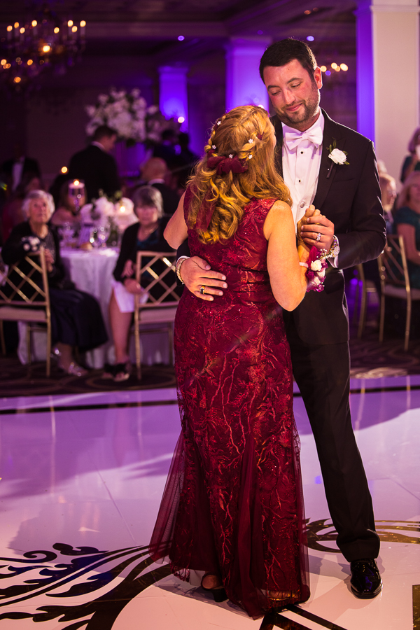 wedding photographer, lisa rhinehart, captures this colorful, vibrant image of the mother-son dance during this palace wedding reception in somerset nj 