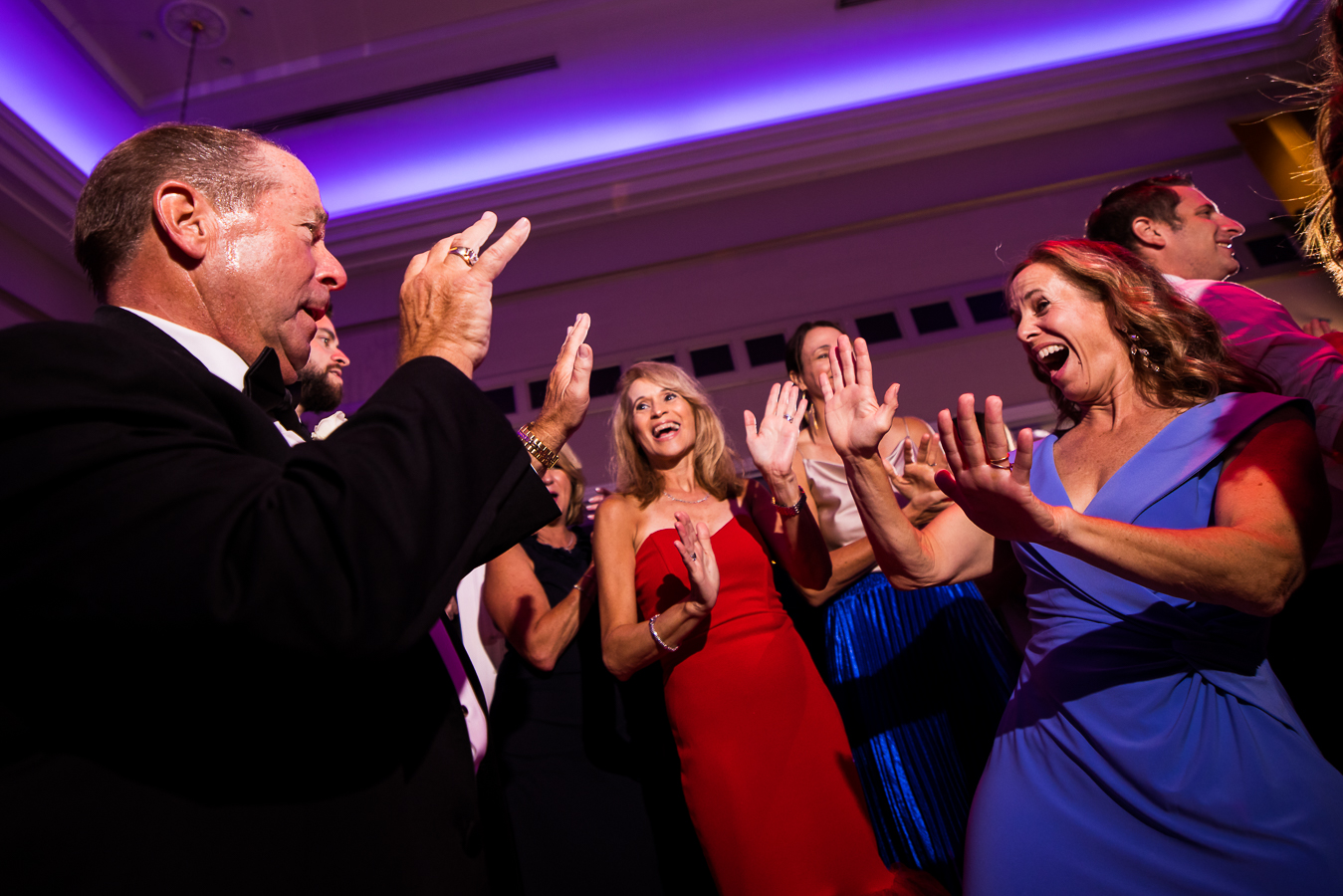 image of guests as they dance together with their hands in the air during this fun wedding reception in NJ 