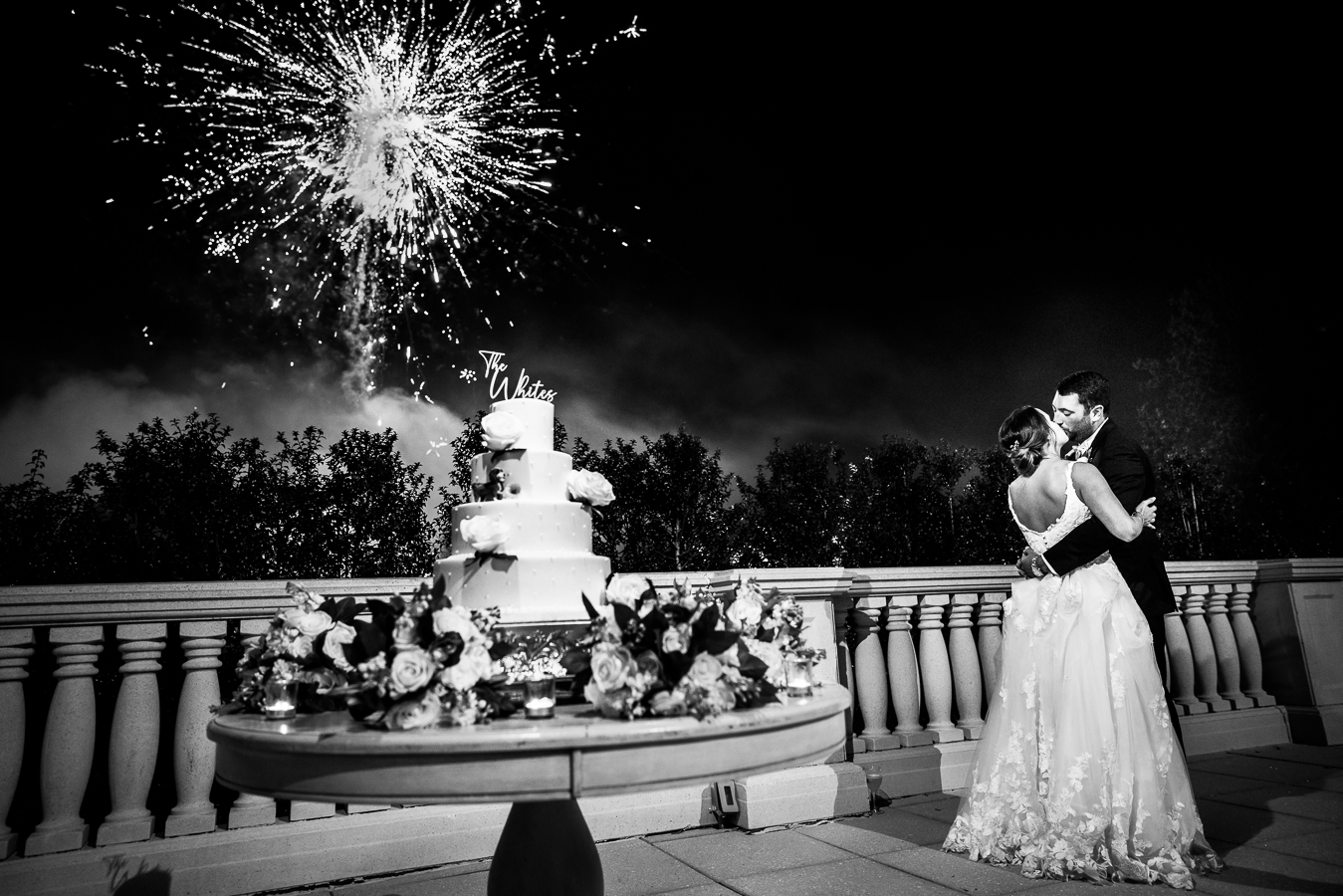 creative nj wedding photographer, lisa rhinehart, captures this spectacular shot of the bride and groom as they share a kiss during the firework display at their black and gold wedding reception at the palace at somerset park in NJ 