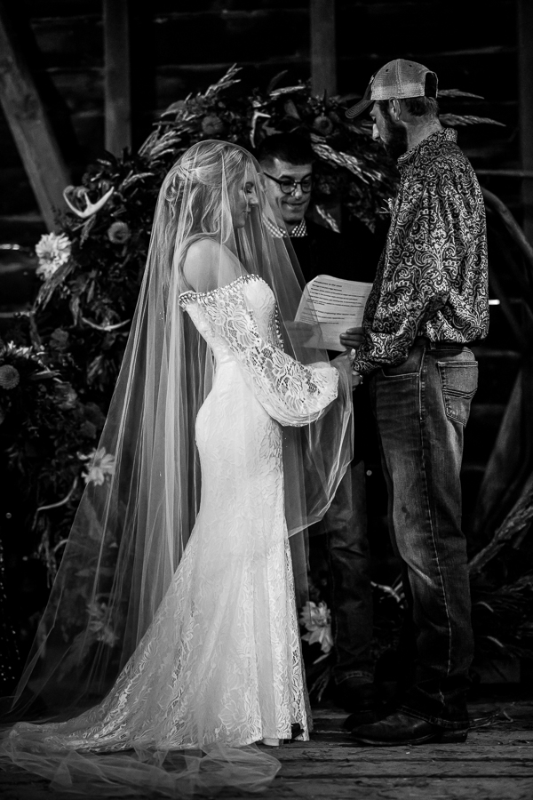 best pa country wedding photographer, lisa rhinehart, captures this black and white sentimental moment between the bride and groom as they hold hands and share a pray together during their barn wedding ceremony in halifax pa 