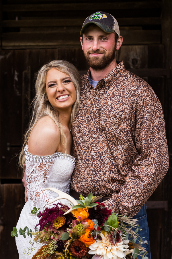 pa wedding photographer, lisa rhinehart, captures this traditional portrait of the bride and groom as they stand hugging one another after their country barn wedding ceremony in halifax pa 