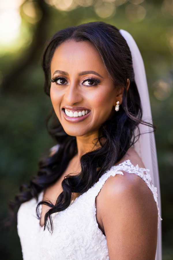 dc wedding photographer, Lisa Rhinehart, captures this traditional portrait of the bride as she smiles at the camera in her wedding gown and veil outside of st francis hall 