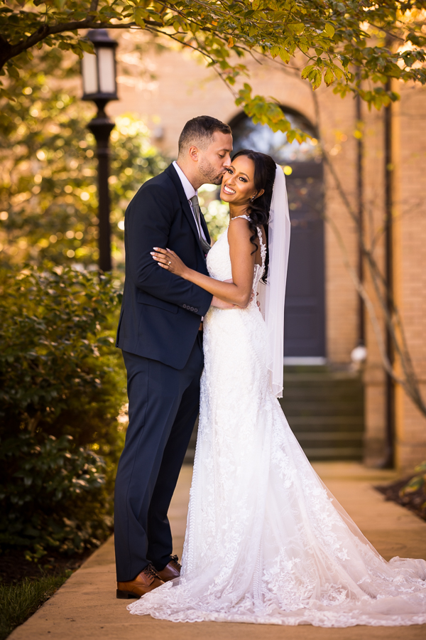 st francis hall wedding photographer, Lisa Rhinehart, captures this traditional portrait of the bride and groom as the groom kisses his Ethiopian bride before their Ethiopian infused wedding ceremony at st francis hall in Washington DC 