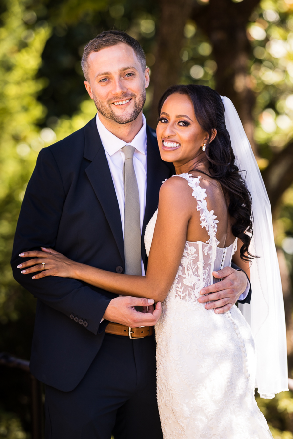 wedding photographer, Lisa Rhinehart, captures this traditional portrait of the bride and groom as they hug one another and smile back at the camera before their st francis hall wedding ceremony 