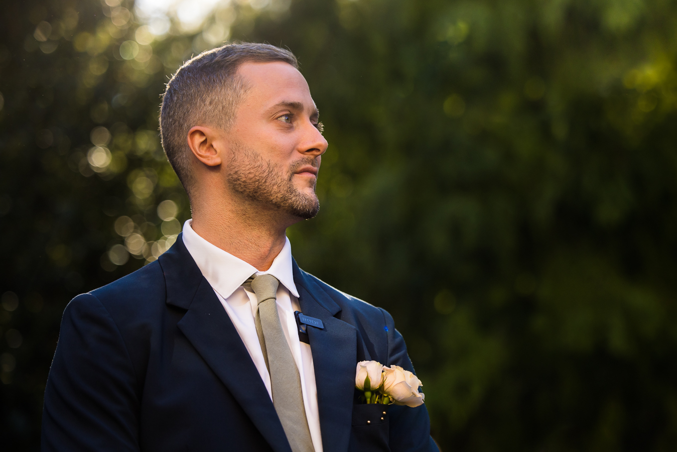 close up image of the groom as he watches his Ethiopian bride walk down the aisle towards him during this outdoor st francis hall wedding ceremony captured by dc wedding photographer, Lisa Rhinehart 