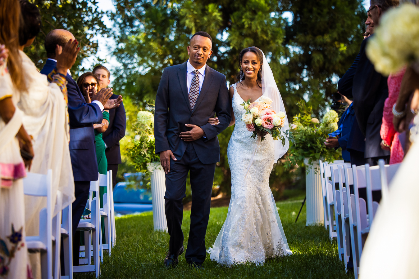vibrant, colorful image of this Ethiopian bride as she walks down the aisle at her outdoor multicultural st francis hall wedding ceremony captured by wedding photographer, Lisa Rhinehart 