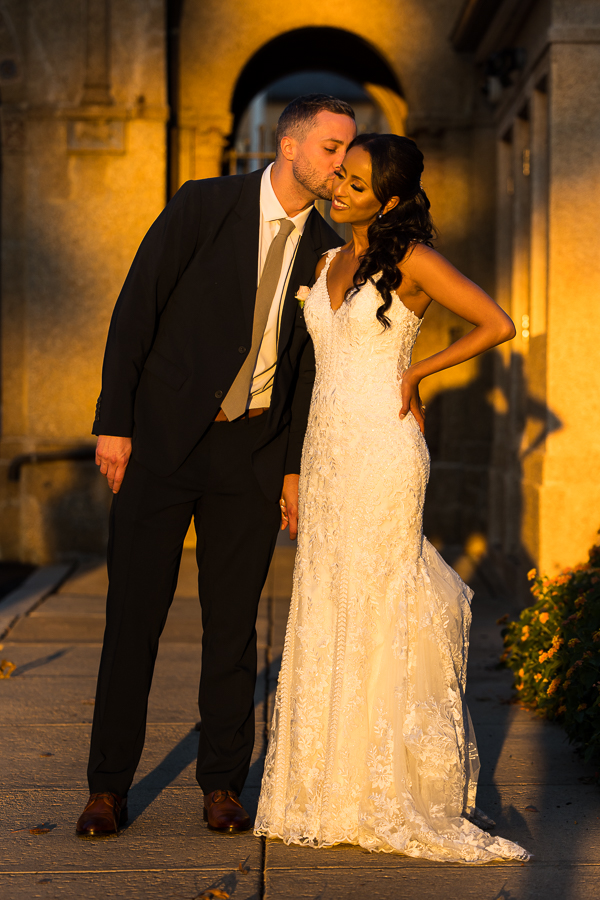 Multicultural DC Wedding photographer, Lisa Rhinehart, captures this image of the groom kissing his Ethiopian bride in the golden hour light during their romantic portrait session at st francis hall in Washington DC