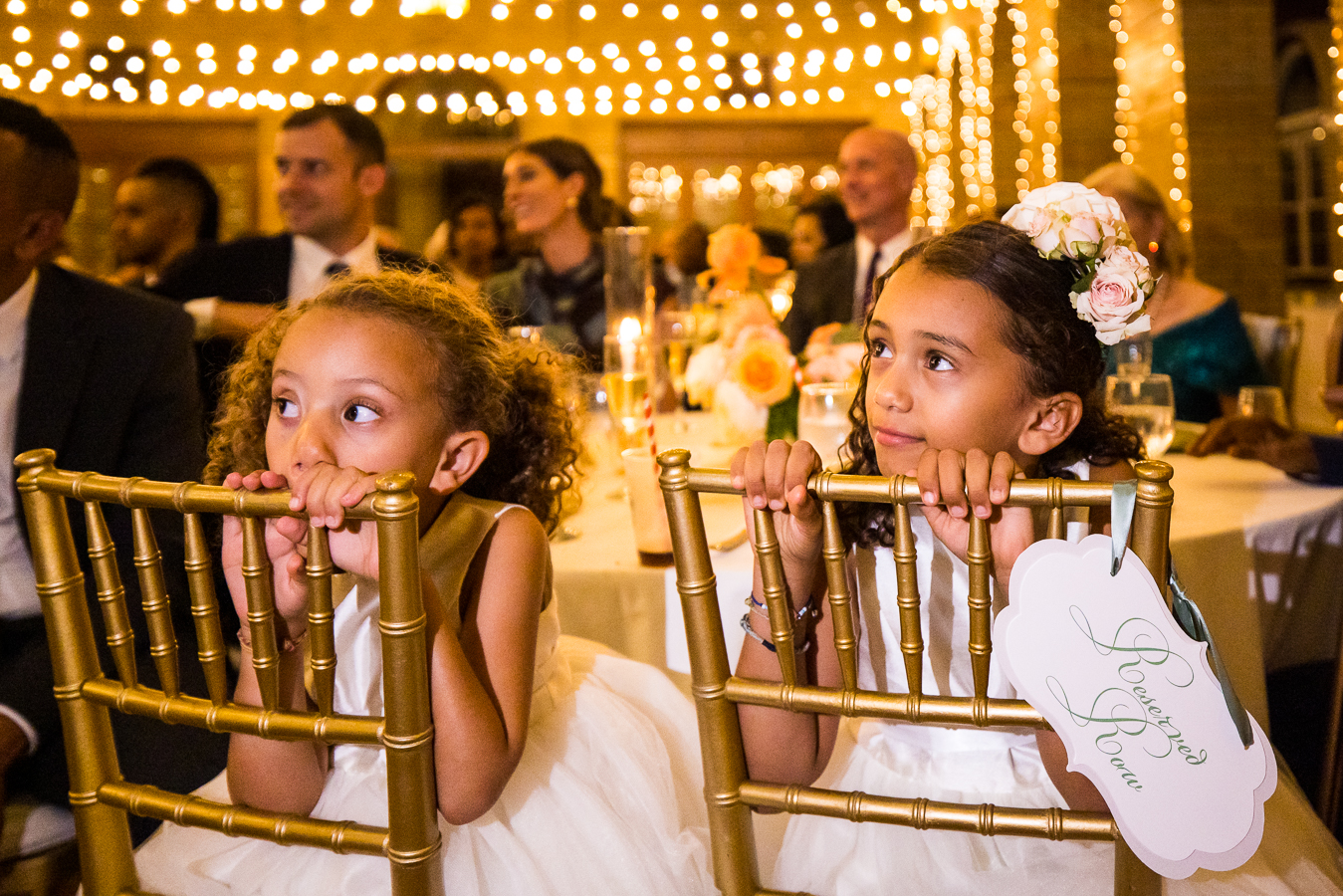 candid wedding photographer, lisa rhinehart, captures this image of the flower girls as they watch the groom and his Ethiopian bride share their first dance together during this multicultural wedding reception at st francis hall in dc