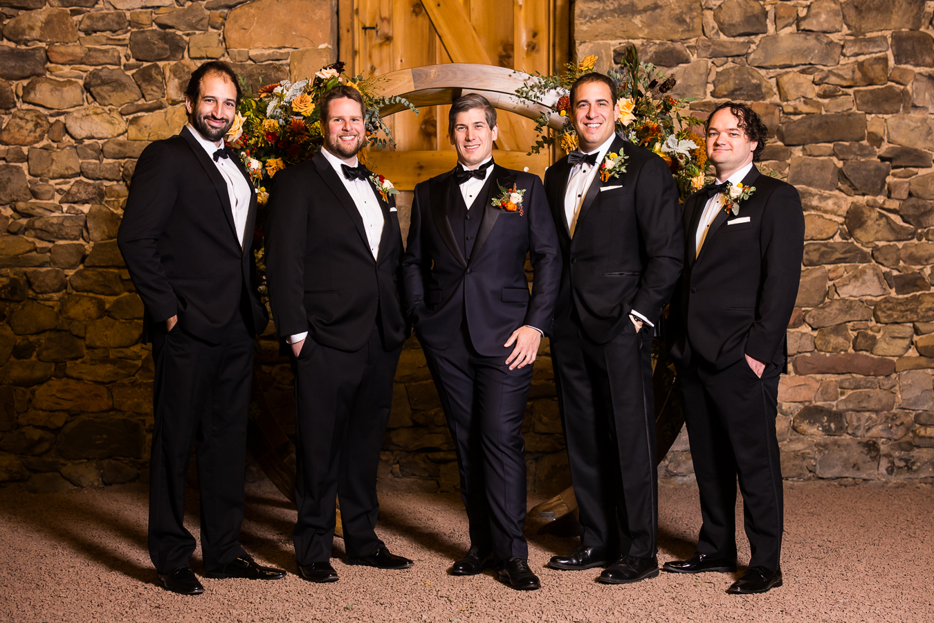 traditional portraits of the groomsmen as they stand in a line together and smile at the camera during this lancaster county wedding in pa
