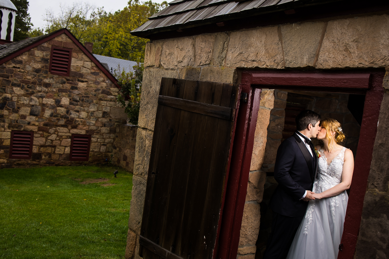 unique perspective of the bride and groom as they share a kiss together inside of the stone building during their rainy day wedding at Elizabeth furnace in lititz, pa 