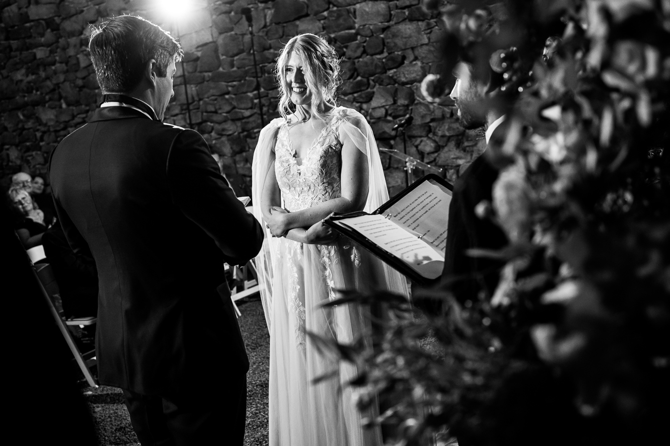black and white candid moment of the bride and groom as they share their vows and smile at each other during this Elizabeth Furnace Wedding ceremony in Lancaster pa 