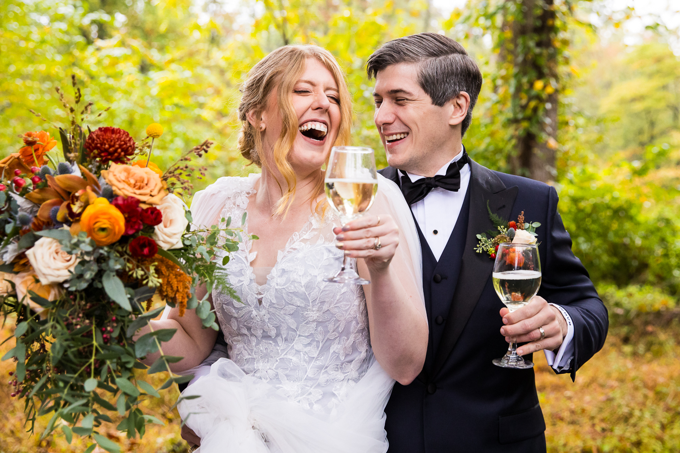 Elizabeth Furnace Wedding photographer, lisa rhinehart, captures this joyful, vibrant moment between the bride and groom as they smile and laugh at each other as they hold their wine glasses outside in the woods for this rainy day wedding ceremony in lititz, pa 