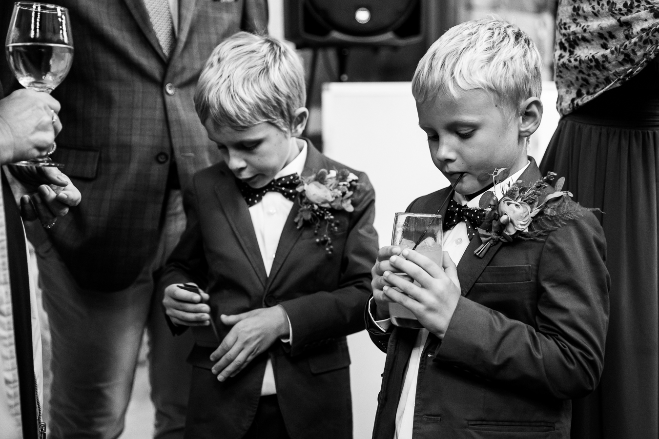 black and white candid moment of the ring bears as they sip on their drinks during cocktail hour at this Elizabeth Furnace Wedding reception in lititz, pa 