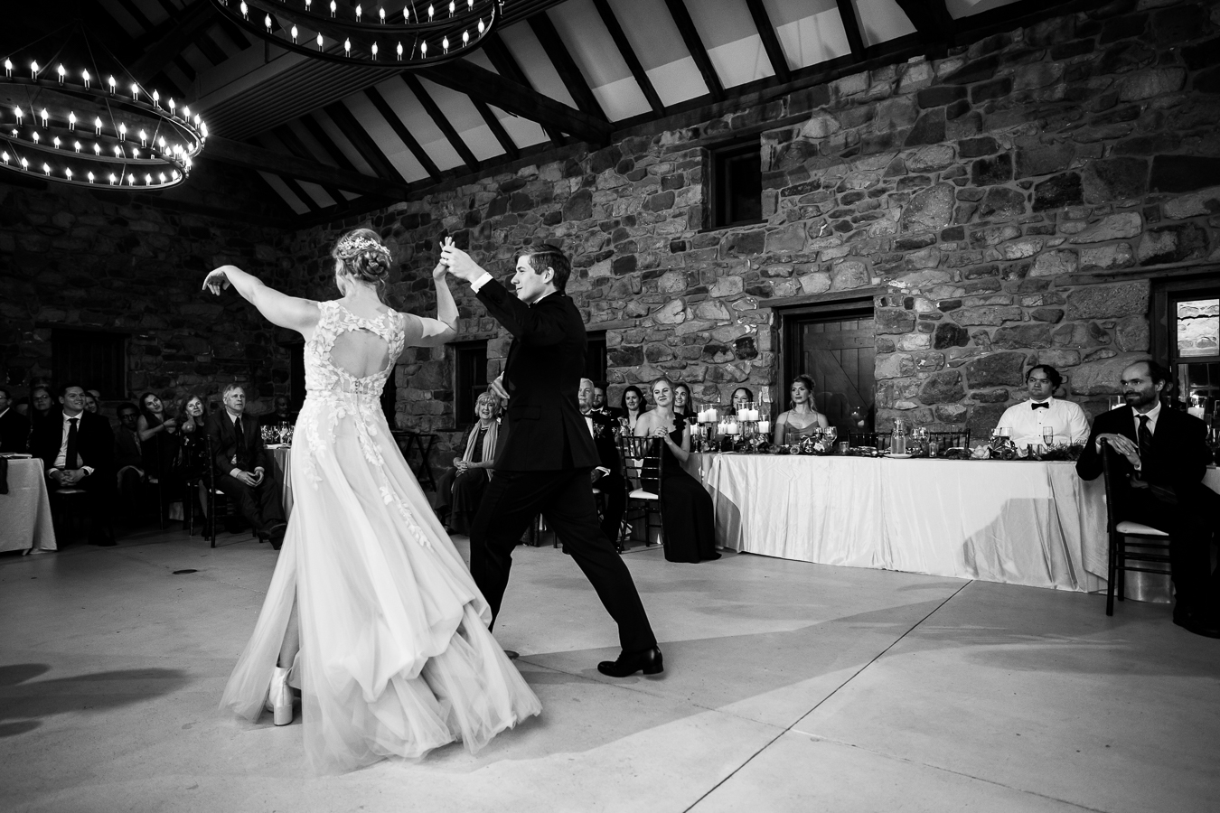 black and white image of the couple as they share their first dance with one another during their indoor wedding reception at the furnace is lancaster pa 