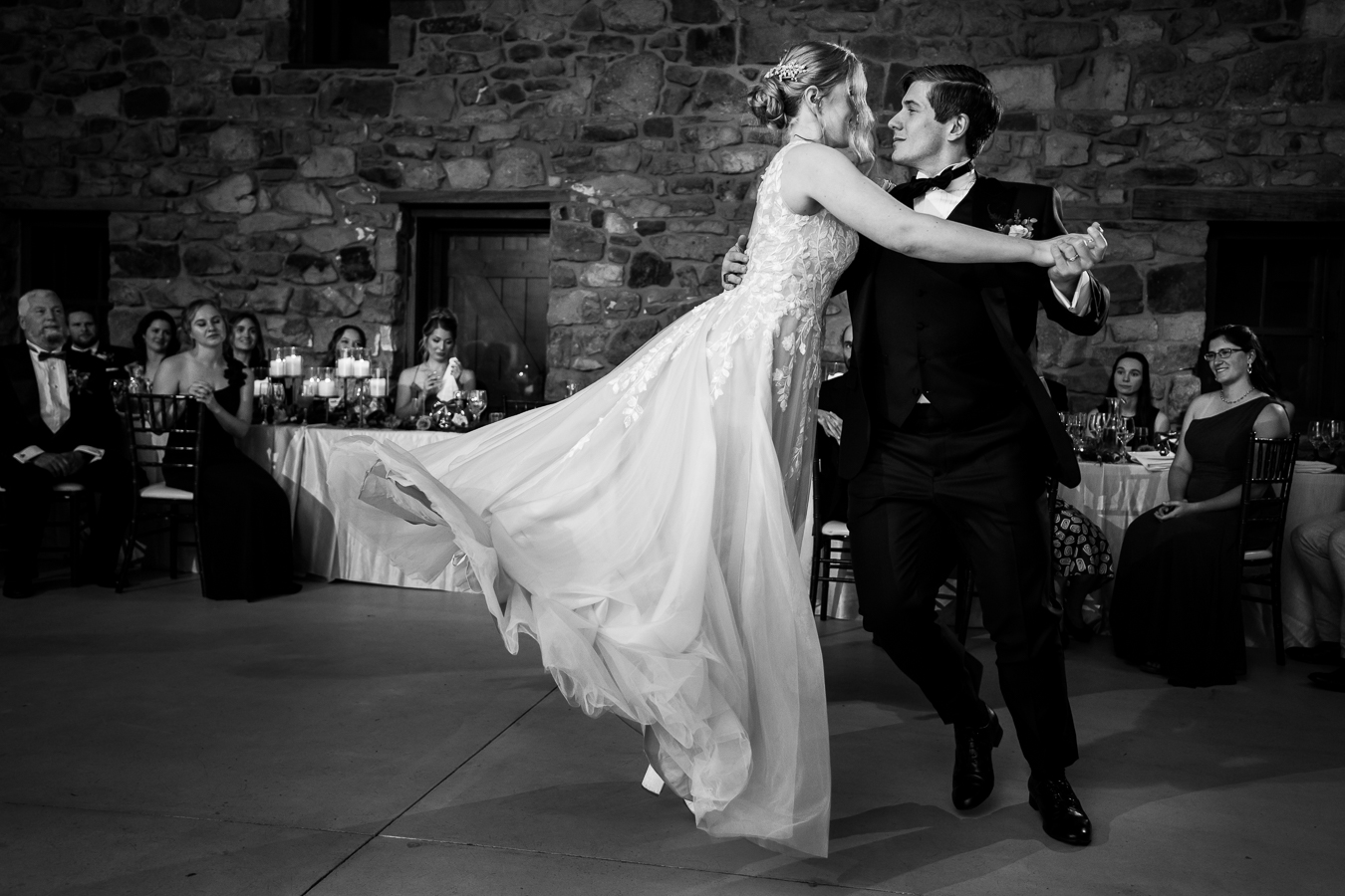 Elizabeth Furnace Wedding photographer, lisa rhinehart, captures this black and white candid moment between the bride and groom as dance their first dance and the bride is spun around on her toe to look like she is flying 