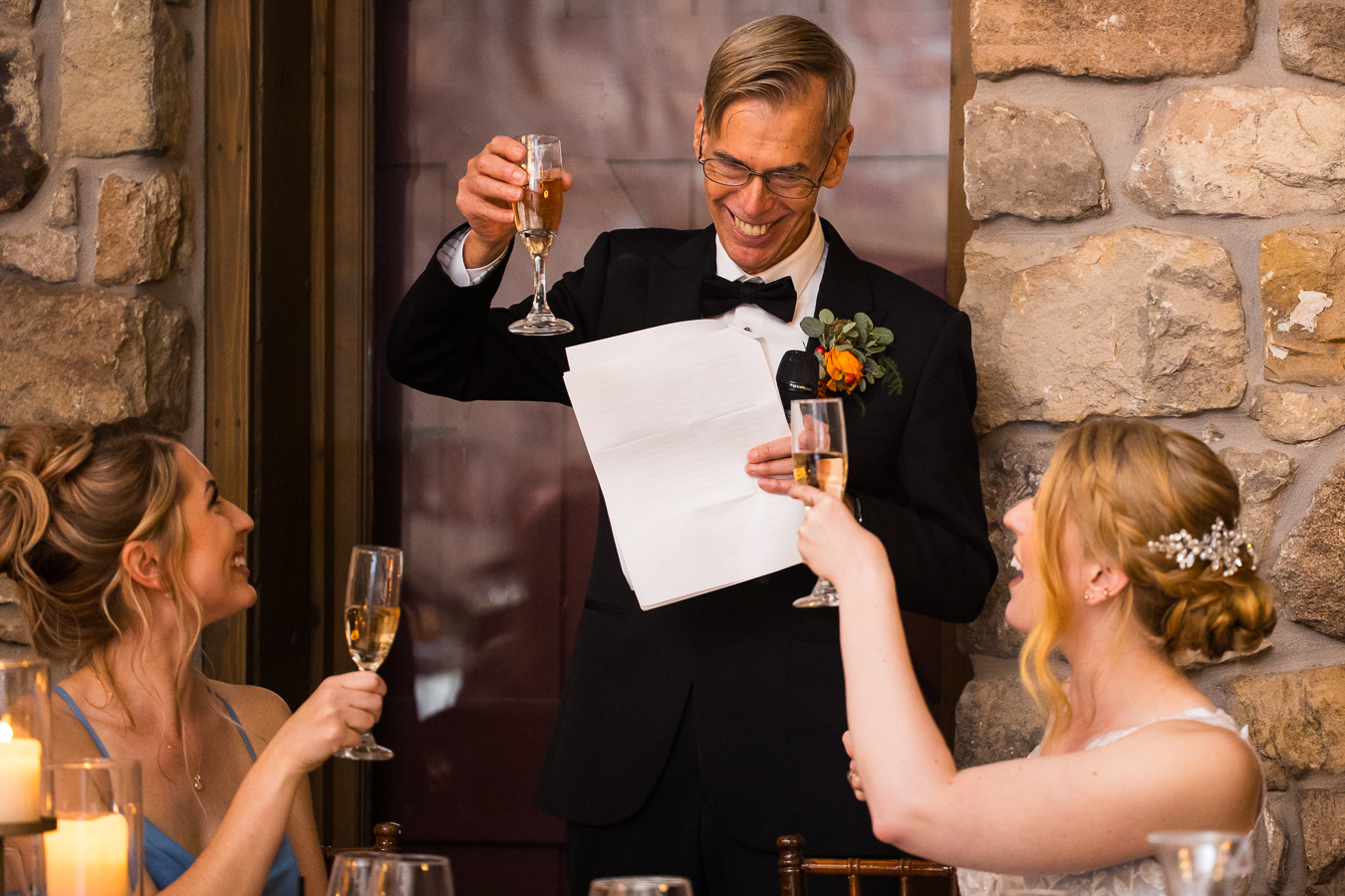 candid image of the brides father as he shares his speech and toasts during the wedding traditions portion of the reception