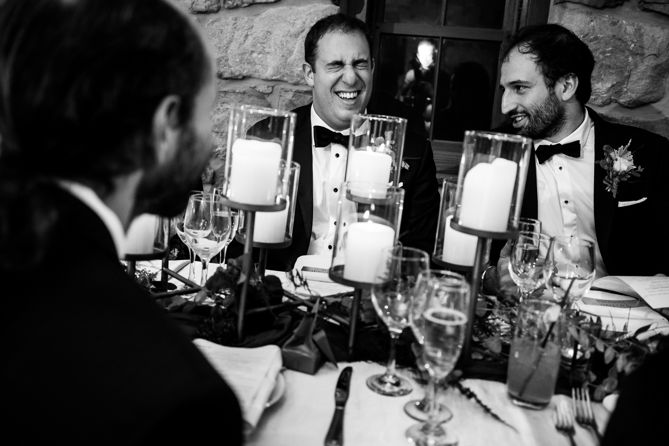 Elizabeth Furnace Wedding photographer, lisa rhinehart, captures this black and white image of the groomsmen as they laugh and smile during the speeches at this indoor wedding reception 