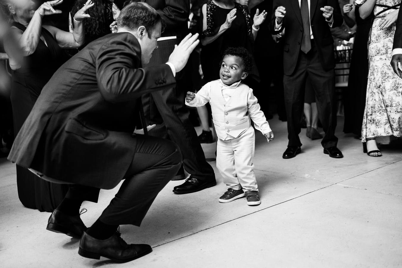 pa wedding photographer, lisa rhinehart, captures this black and white image of a guest dancing with the baby during this Elizabeth Furnace Wedding reception 