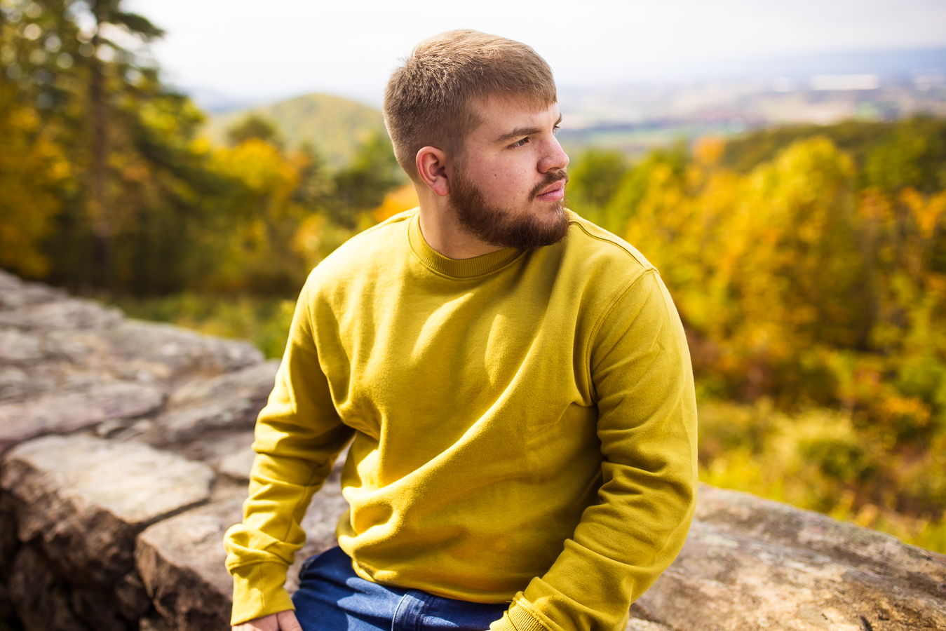 kings gap mansion portrait photographer, lisa rhinehart, captures this portrait of this high school senior as he looks off the overlook at kings gap surrounded by vibrant fall foliage in pa