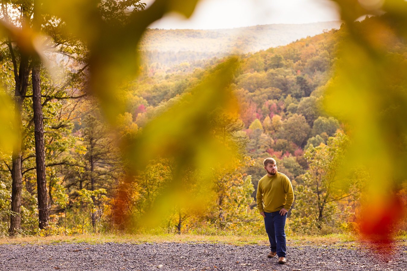 vibrant, colorful image of this senior as he stands ontop of kings gap in central pa surrounded by vibrant fall foliage during this outdoor senior portrait session 