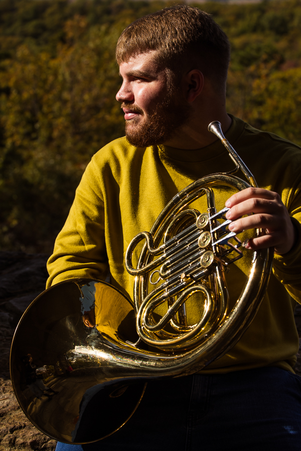 image of this male with cerebral palsy as he shows how he can play his french horn and does not let a disability stop him during this creative portrait session in central pa 