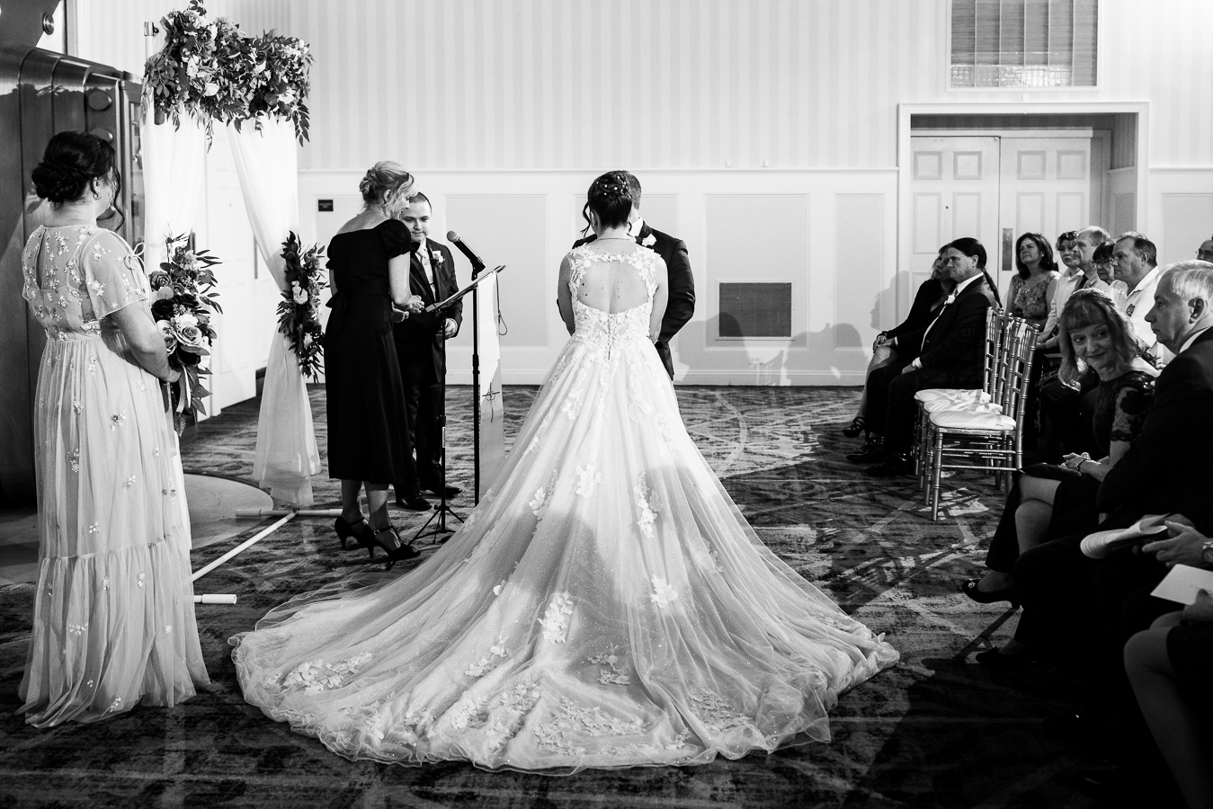 gettysburg hotel wedding photographer, lisa rhinehart, captures this black and white image of the bride's dress and her train laid out during their wedding ceremony inside of the Gettysburg hotel 