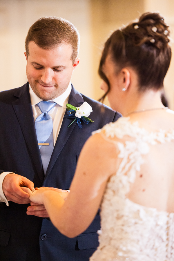traditional portrait of the bride and groom as they exchange wedding rings during this wedding ceremony in a historic wedding venue 