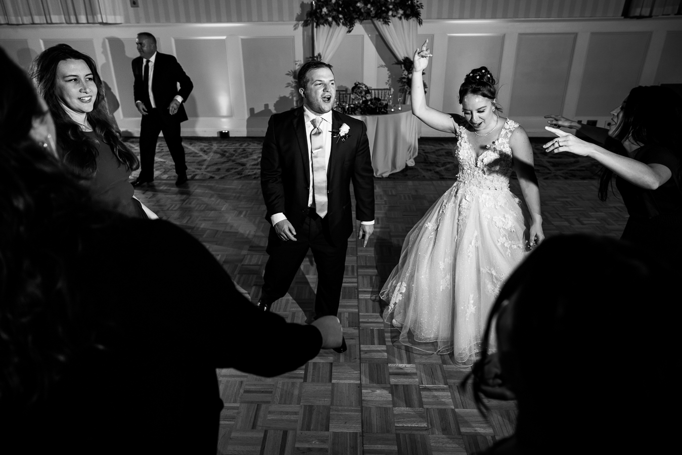 black and white image of the bride and groom as they sing, laugh and dance with guests at their historic wedding venue in Gettysburg pa during their wedding reception 