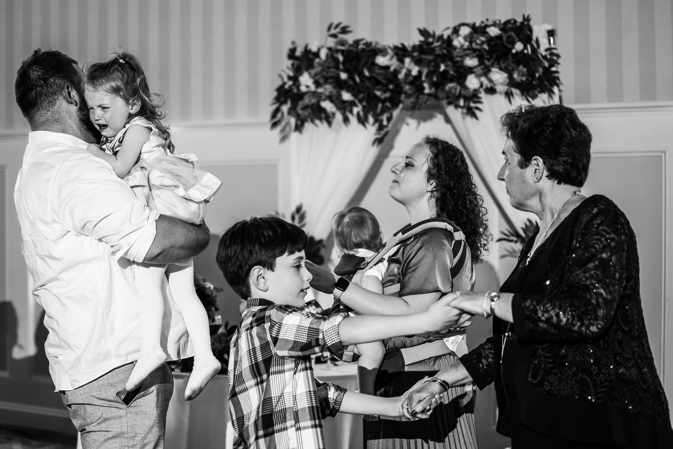 candid wedding photographer, lisa rhinehart, captures this black and white image of guests as they dance together with children during this Gettysburg hotel wedding reception 