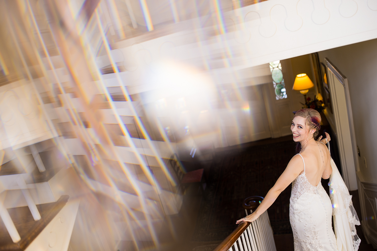 creative Murray Hill wedding photographer, lisa rhinehart, captures this creative, unique bridal portrait of the bride as she walks down the stairs with creative reflections and rainbows captured