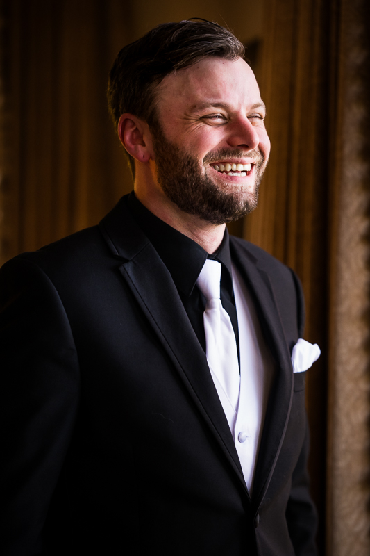 leesburg va wedding photographer, lisa rhinehart, captures this portrait of the groom as he smiles and laughs before heading to his outdoor fall wedding ceremony 