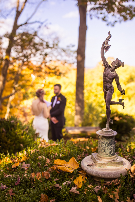 creative, unique image of the bride and groom as they share their intimate vows before their outdoor wedding ceremony in Leesburg va surrounded by the vibrant fall foliage of virgina 