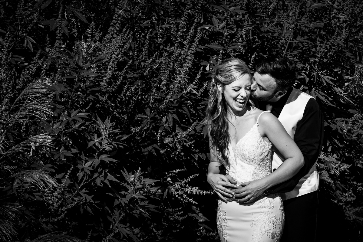 Murray Hill wedding photographer, lisa rhinehart, captures this black and white image of the the bride and groom as they hug one another and smile and laugh during their outdoor first look