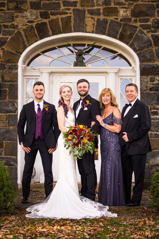 traditional portrait of the bride and groom with their families as they pose for family photos after the wedding ceremony in Virginia 