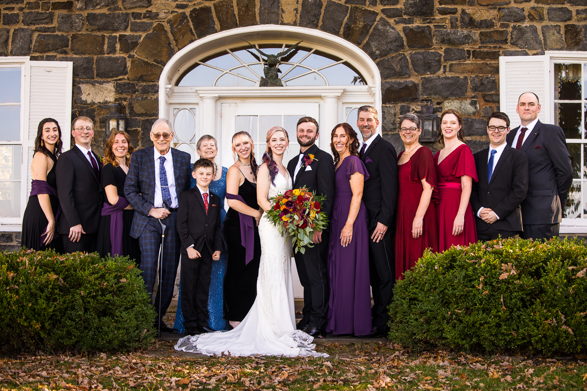 traditional portrait of the bride and groom with their families as they take family portraits after this outdoor wedding ceremony in Virginia 