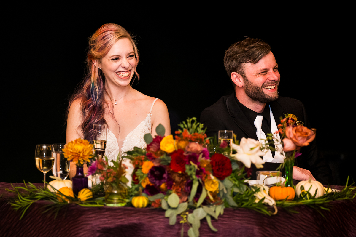 Murray Hill Wedding Photographer, lisa rhinehart, captures this authentic candid image of the bride and groom as they laugh and smile while their friends and family give their speeches during this barn wedding reception in Leesburg pa beside the Potomac river