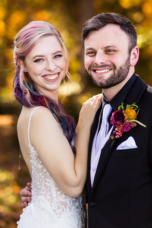 Murray Hill wedding photographer, lisa rhinehart, captures this traditional portrait of the bride and groom as they hug one another and smile at the camera during their outdoor vibrant fall first look
