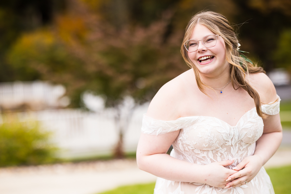 candid, vibrant image of the bride as she smiles at her groom for the first time during their outdoor fall first look outside of the omni in Bedford springs pa captured by creative Omni wedding photographer, lisa rhinehart